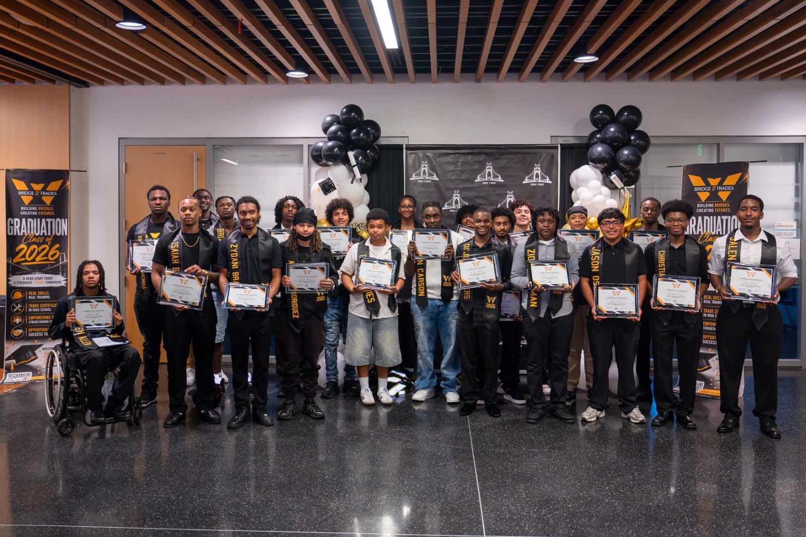 Bridge 2 Trades Class of 2026 graduates holding their certificates